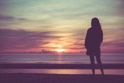 Kvinne ved havet i solnedgang