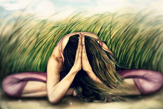 kvinne mediterer i gresset