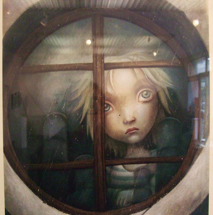 trist barn ser ut av vinduet