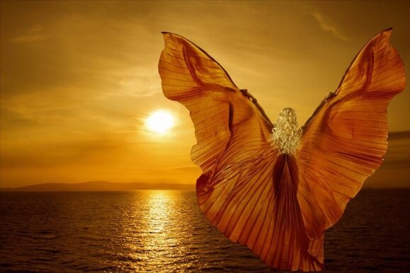 Kvinne ved havet med vinger