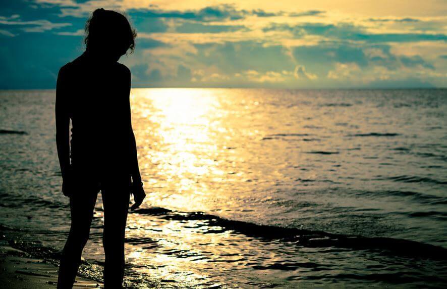 Person ved havet i solnedgangen