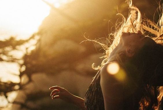 Lykkelig kvinne i solen