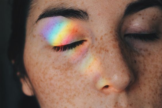 Kvinne med regnbuefarget gjenskinn i ansiktet