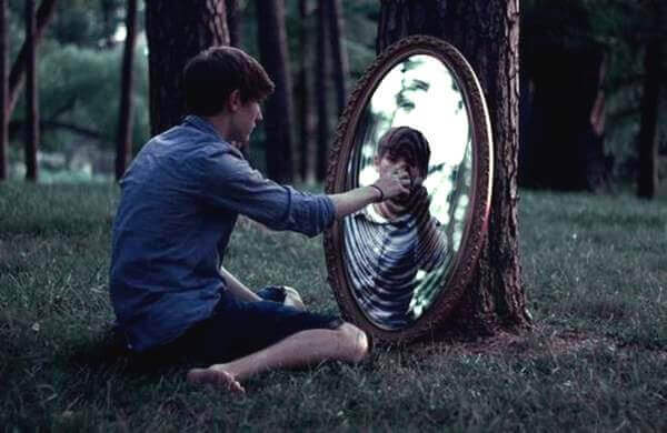 Gutt ser i speil i skogen