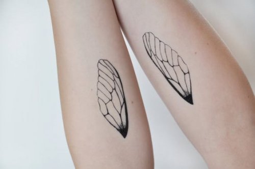 Hender med tatoveringer av vinger