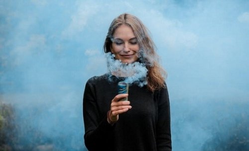 Kvinne smiler, omgitt av røyk
