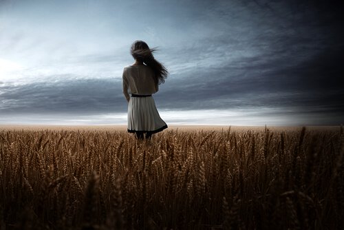 En jente i en hveteåker som tenker på muligheter