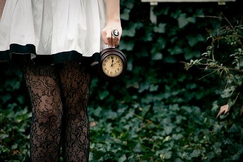 En jente som holder en klokke