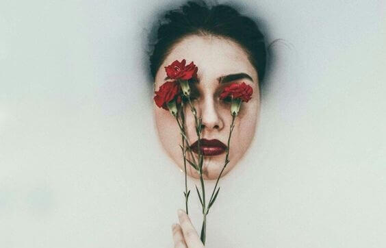 Kvinne med blomst foran ansiktet