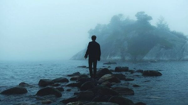 en ensom mann i et regnfullt hav