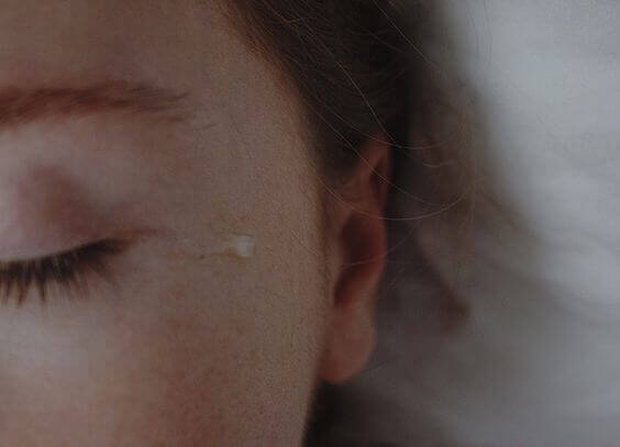 Tåre faller fra kvinnes øyne