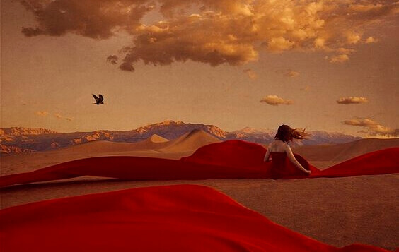 Kvinne med rød kjole i ørkenen