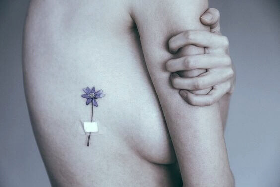 Tattovering av blomst dekt av plaster