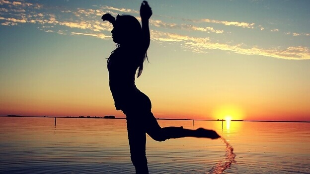 Kvinne danser ved havet