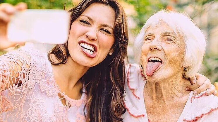 en eldre kvinne og en ung kvinne som tar en selfie