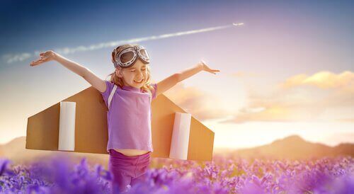 Et lykkelig barn med pappvinger som et fly