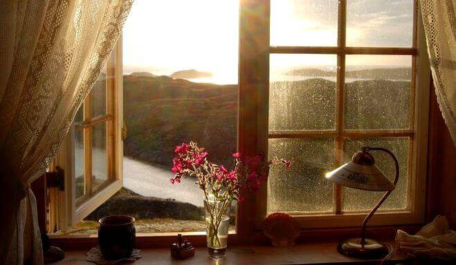Et åpent vindu som viser et vakkert landskap.