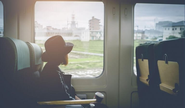 En jente sitter ombord på et tog.