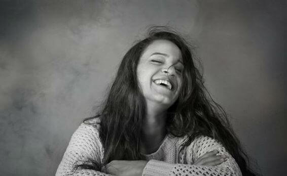 En glad kvinne ler.