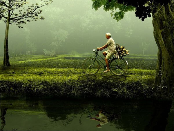 Du kan gjøre det: en eldre mann som sykler ved en dam.