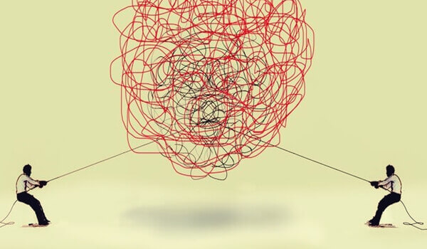 To personer trekker i to tråder for å løse en floke