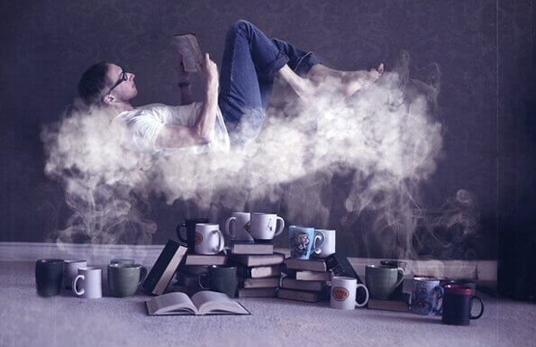 Lesing og hjernen: En mann leser en bok på en sky av damp fra mange kaffekopper.