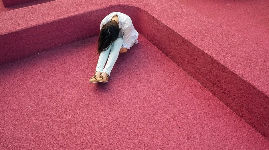 Person sitter i hjørne