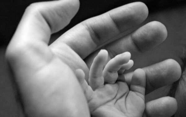 En babyhånd i en voksen hånd.