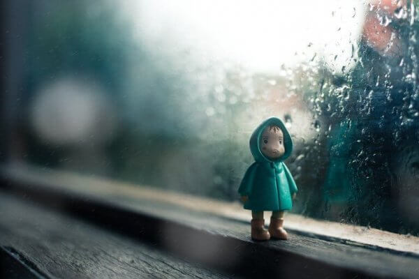 en dukke av et barn iført en regnfrakk