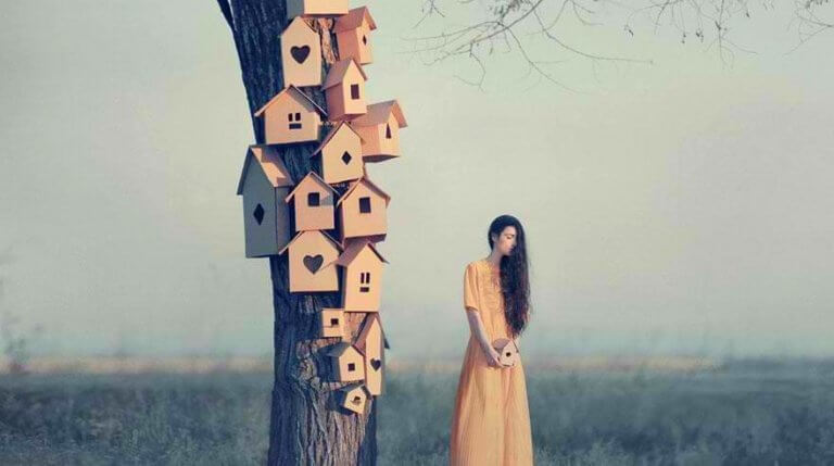 En kvinne ved siden av mange fuglehus