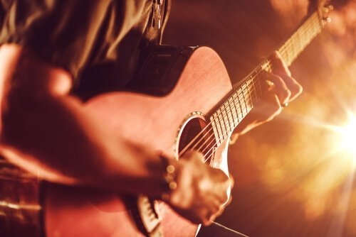 Spiller gitar foran et publikum.