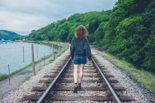 Kvinne går langs togskinne