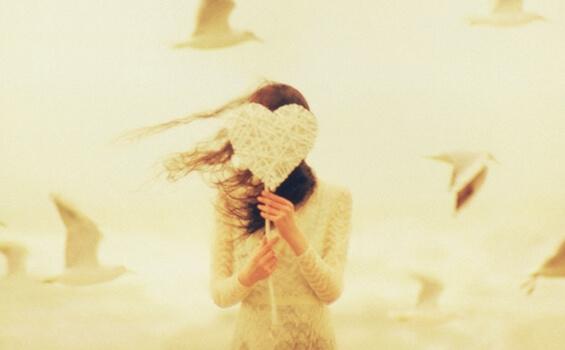 Kvinne med hjerte foran ansiktet