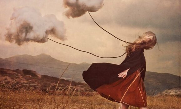 Jente drar skyer i en tråd