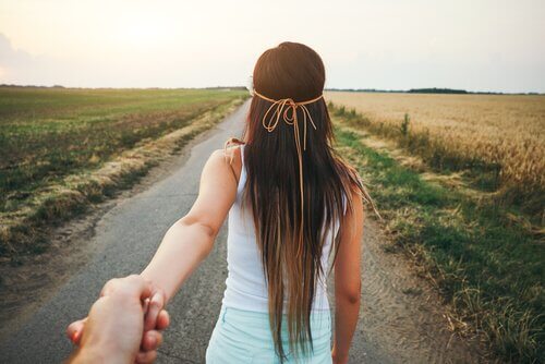 Jente leder kjæresten sin i hånden