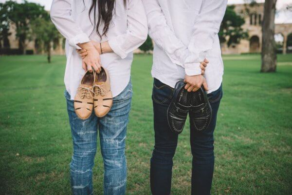 Par som står å holder sko