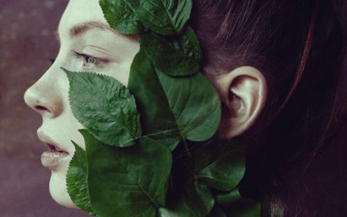 Kvinne med blader i ansiktet