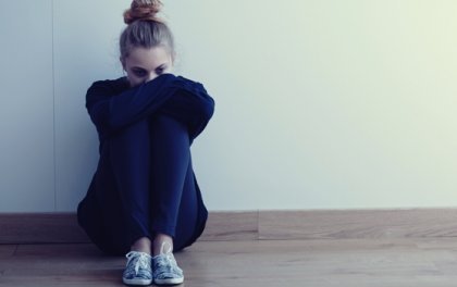 En kvinne opprørt med knærne til brystet sitt.