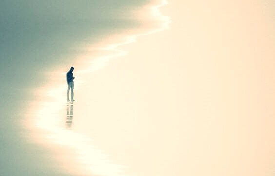 mann på stranden som symboliserer postmoderne ensomhet