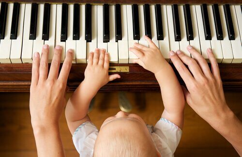 En mor som spiller piano med barnet sitt