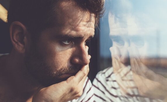 Mann ser ut av vinduet