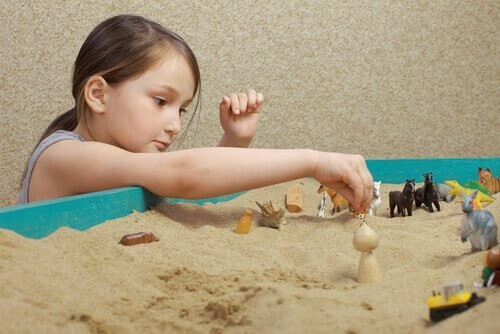 Jente leker med sandkasse
