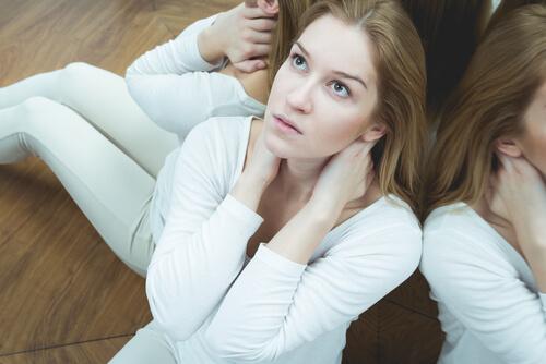 Kvinne som sitter på gulvet og ser opp