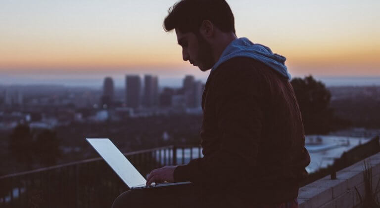 En mann som bruker en bærbar datamaskin for å lykkes på jobb