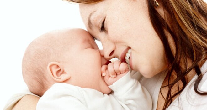 Mor smiler til babyen