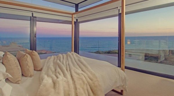 Et luksuriøst rom med glassvegger på stranden