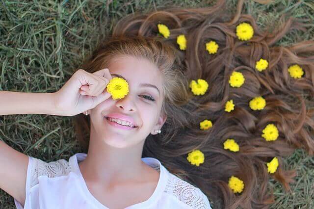 En kvinnelig tenåring har en blomst over øyet.