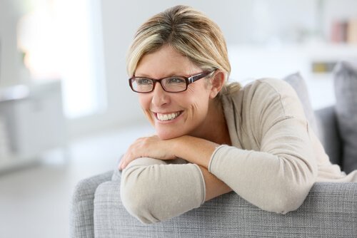 Moden kvinne smiler i sofaen