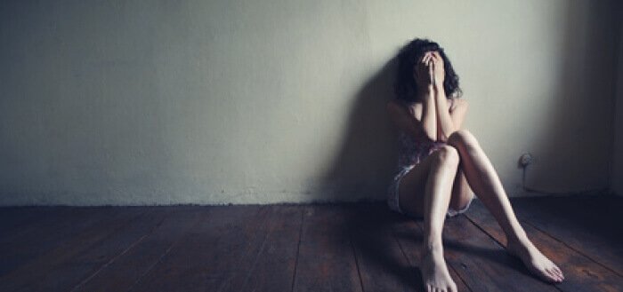 Kvinne med schizofreni sitter på gulvet
