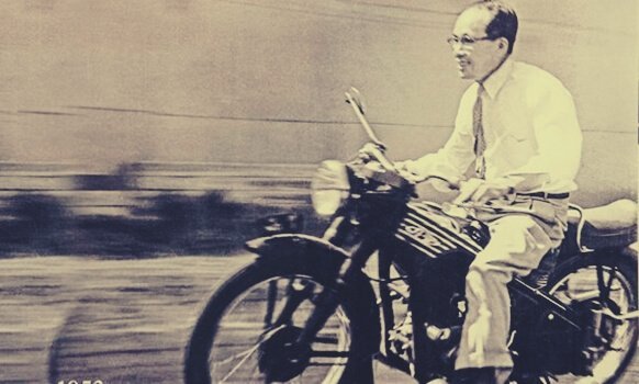 Soichiro Honda kjører en motorsykkel